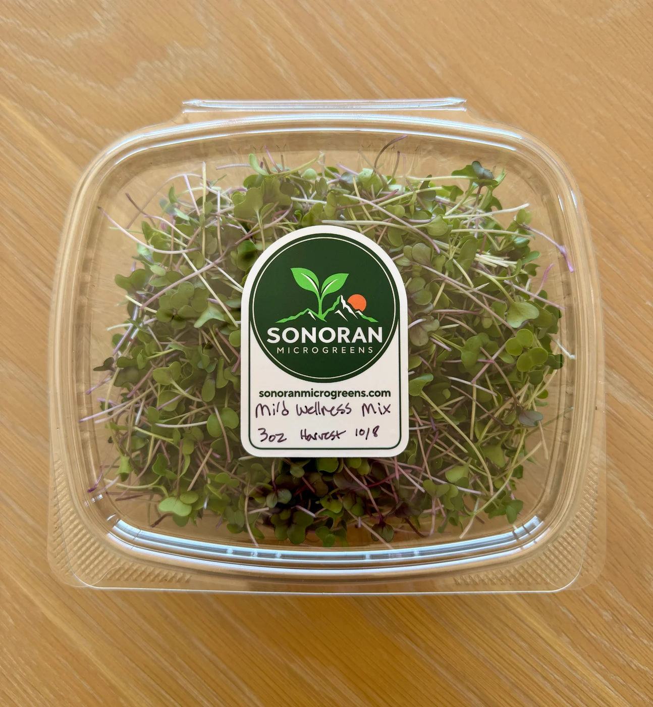 Fresh Mild Wellness Mix in a clear container with a Sonoran Microgreens label